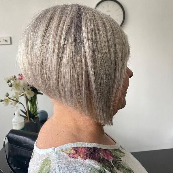 a woman wearing a floral blouse has a has a icy graduated bob cut