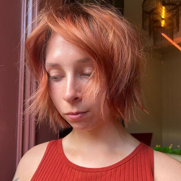 a woman wearing a rust sleeveless top