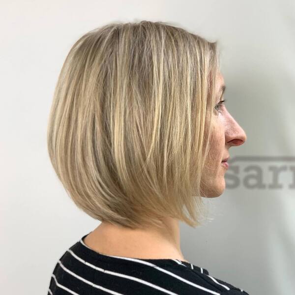 a woman wearing a stripe blouse has a neck-length graduated bob hair