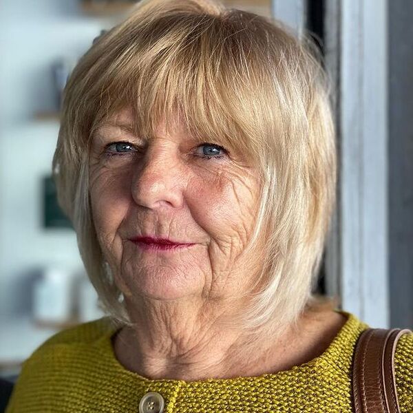 A woman wearing a yellow knitted blouse