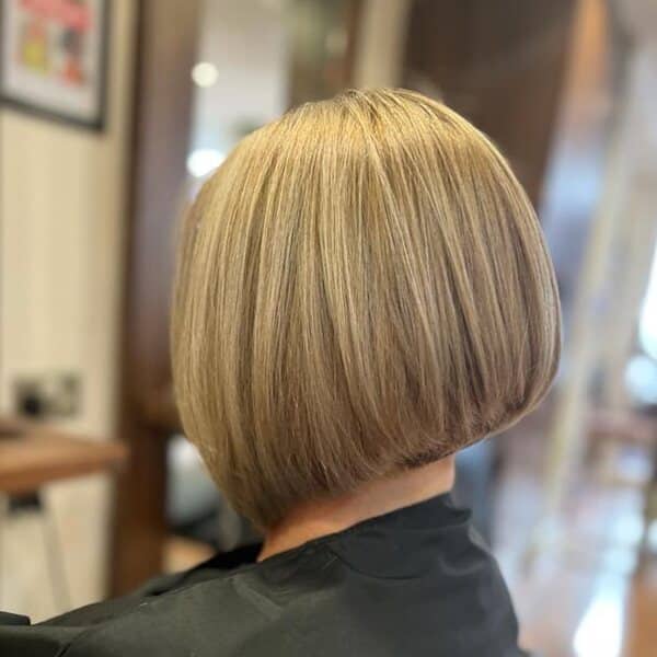 a woman wearing black barbers cape