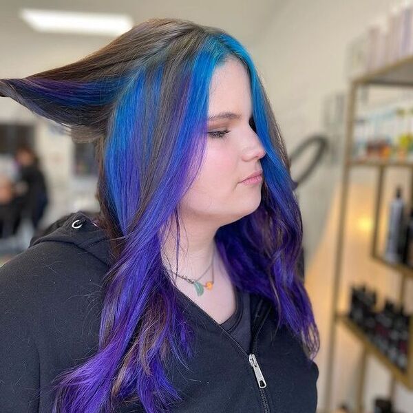 blue and purple hairstyle - a woman wearing a black jacket