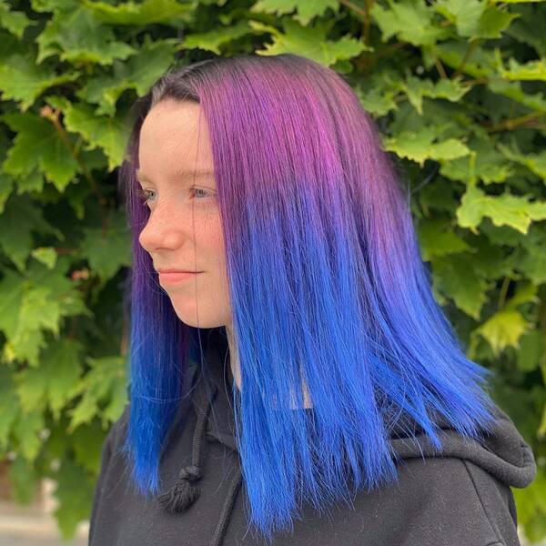 blue and purple hairstyle - a woman wearing a black hooded jacket