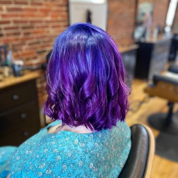 blue and purple hairstyle - a woman wearing a green floral longsleeve