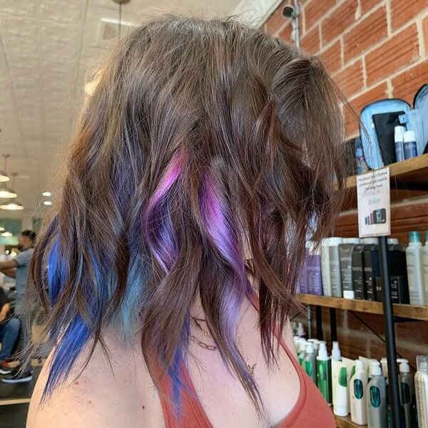 blue and purple hairstyle - a woman wearing a lot of gold necklace