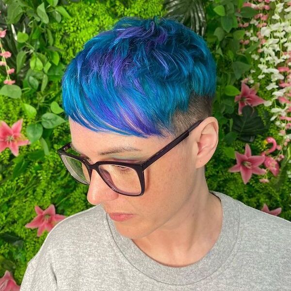 blue and purple hairstyle - a woman with eyeglasses wearing a gray shirt
