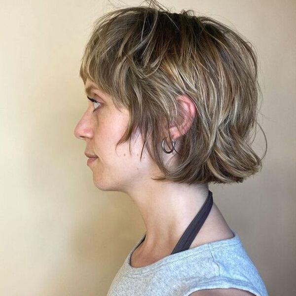 Choppy bob - a woman wearing a gray sleeveless shirt