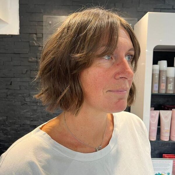 Choppy bob - a woman with a nose piercing and necklace