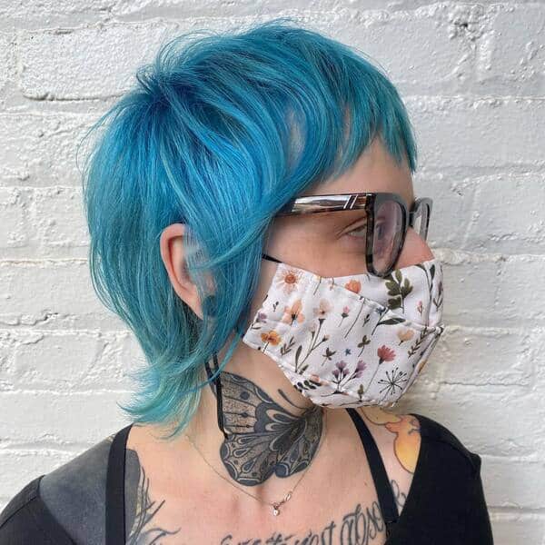 Light Blue Mullet Haircut - a woman wearing a eyeglasses and floral facemask