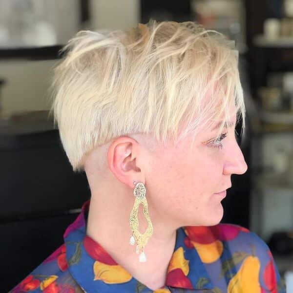 Messy Light Blonde Edgy Cut - a woman wearing long gold earrings