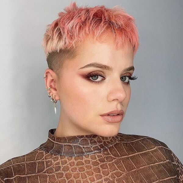 Peach Hair on Pixie Cut - a woman wearing a lot of earrings